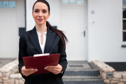 Real estate agent in front of house for sale ready to presenting offer, copy space