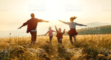 Happy family: mother, father, children son and daughter on nature on sunset