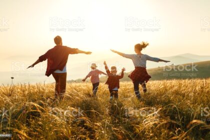 Happy family: mother, father, children son and daughter on nature on sunset